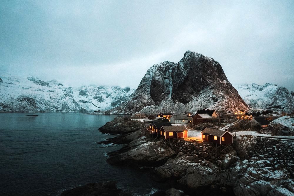 Cabins under a granite peak on a Norwegian fjord