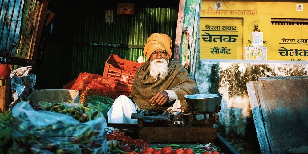 A vegetable seller at his market stall, India