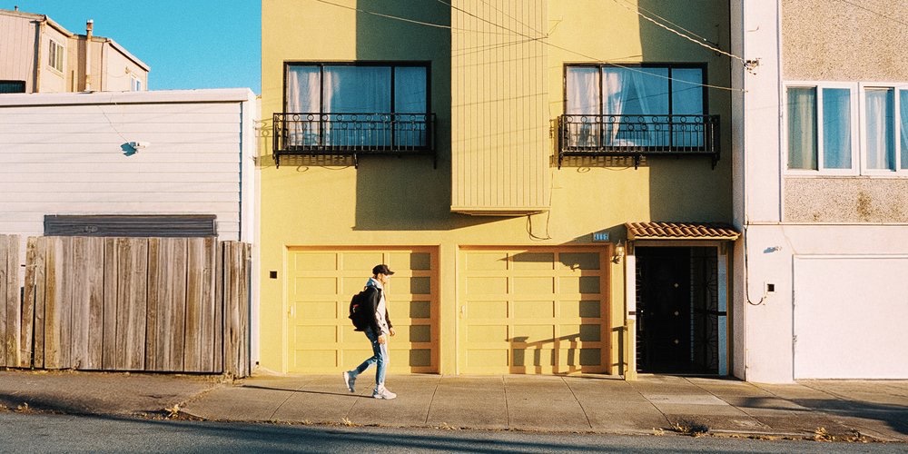 A pedestrian passing a yellow facade