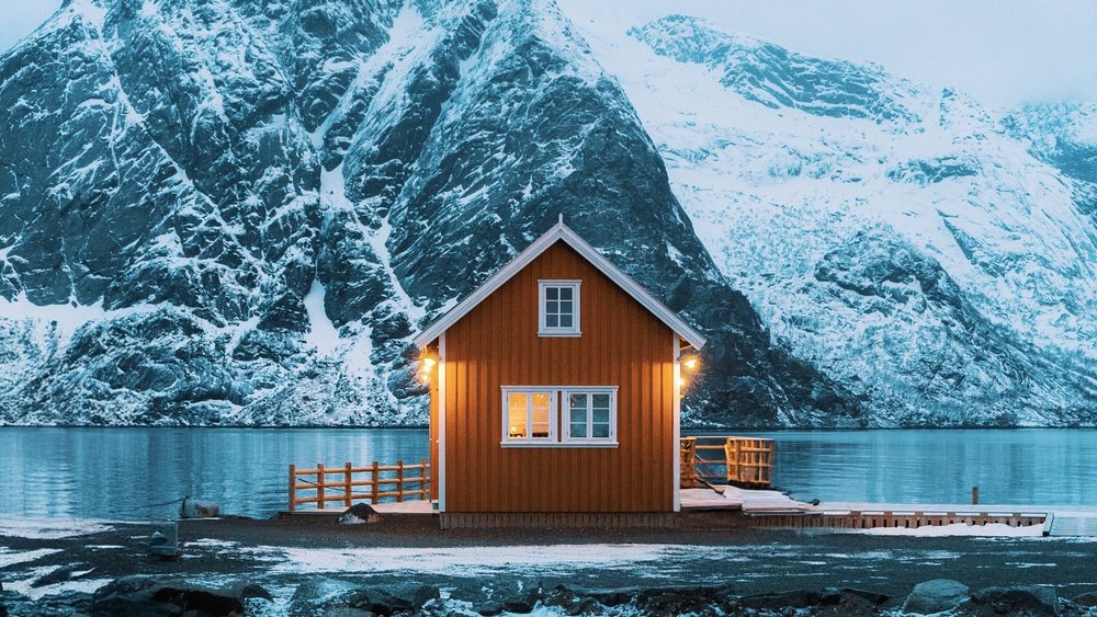 A red cabin on a snowy fjord, Norway