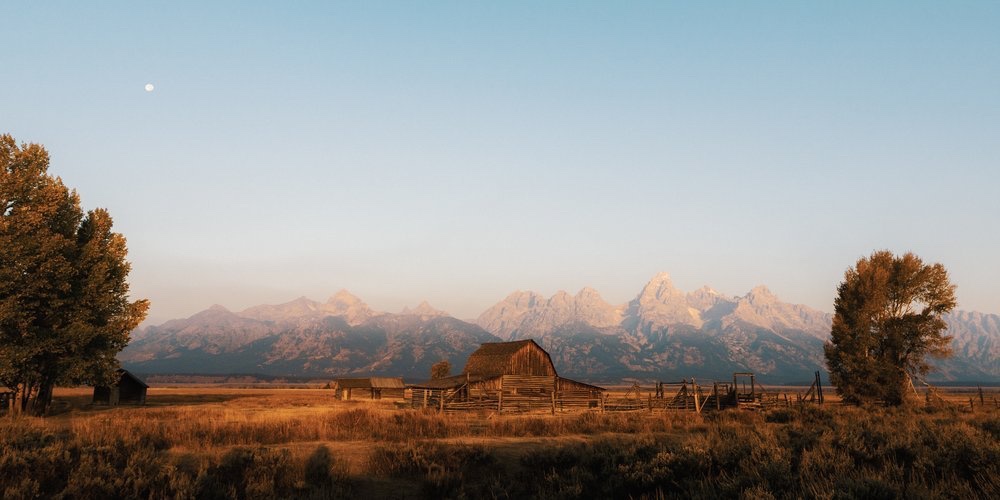 A barn under mountains at dawn