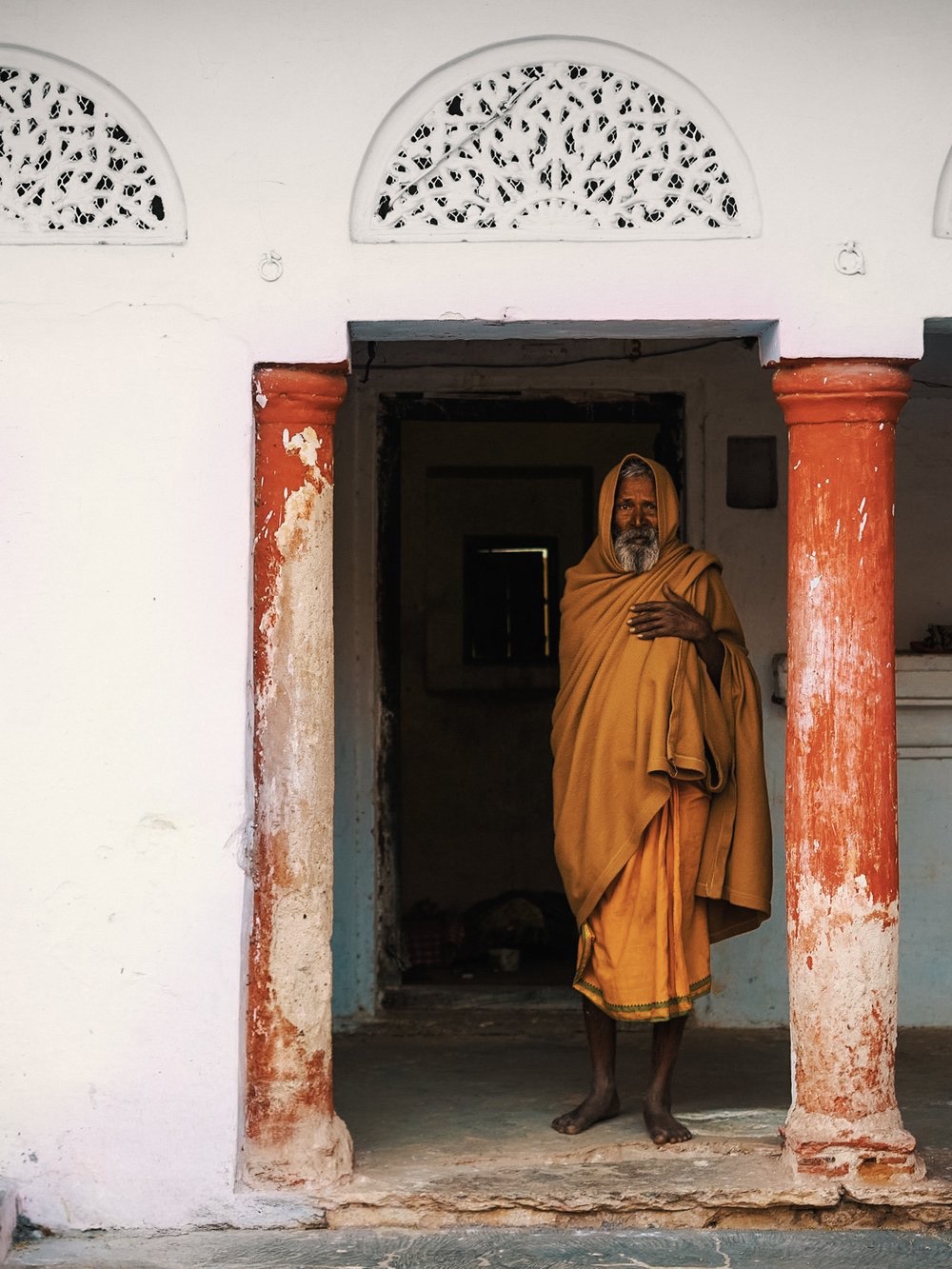 A monk standing in a doorway, India